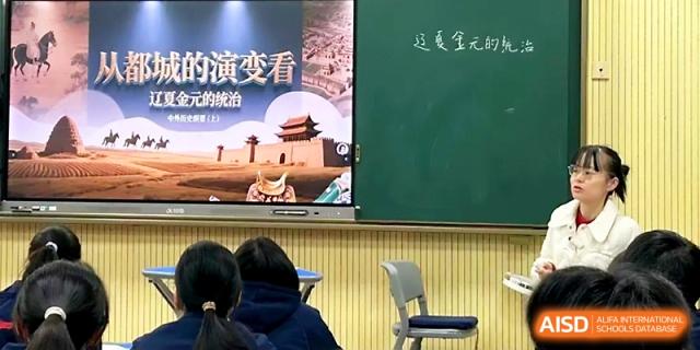 Students observe a presentation on a screen featuring historical architecture and Chinese text in a classroom at Zhejiang ZhouShan High School.