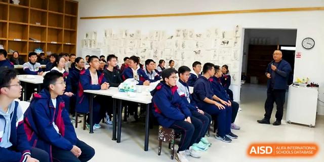 Students sit together at long tables in a well-lit room, participating in a group seminar or club meeting at Zhejiang ZhouShan High School.