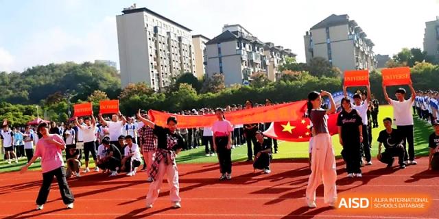 Students proudly carry a large red banner across the track during the opening ceremony of the sports meet at Zhejiang ZhouShan High School.