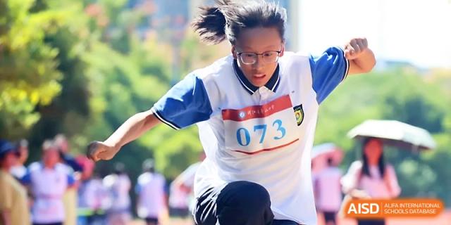 A female runner with glasses sprints toward the finish line during a competitive track race held at Zhejiang ZhouShan High School.