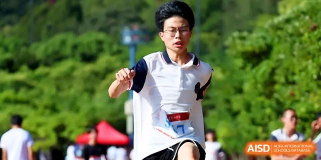 A young male student shows intense focus while competing in a running race on a sunny day at Zhejiang ZhouShan High School.