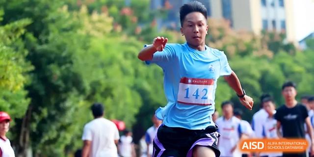 A male runner wearing number 142 sprints with power and determination down the red track at Zhejiang ZhouShan High School.