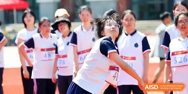 A female student prepares for a race with a look of concentration while standing on the track at Zhejiang ZhouShan High School.