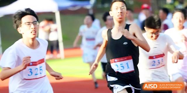 A male student sprints toward the camera during a competitive outdoor running race at Zhejiang ZhouShan High School.