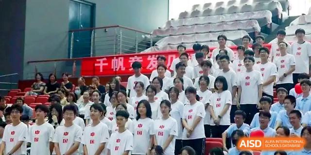 A choir of students in white shirts stands together on bleachers for a musical performance at Zhengzhou No.1 High School