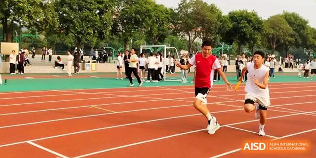 An athlete in a red shirt sprints toward the finish line during a competitive track and field event at Zhengzhou No.1 High School