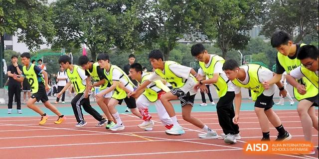 Runners in colorful jerseys wait at the starting blocks for the signal to begin their sprint at Zhengzhou No.1 High School