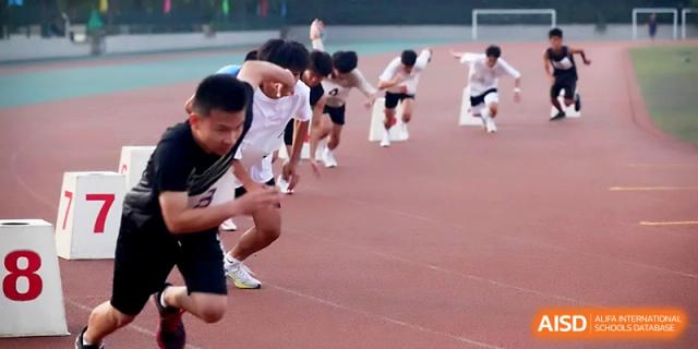 Sprinters lean forward as they burst from the starting line for a short-distance dash competition at Zhengzhou No.1 High School