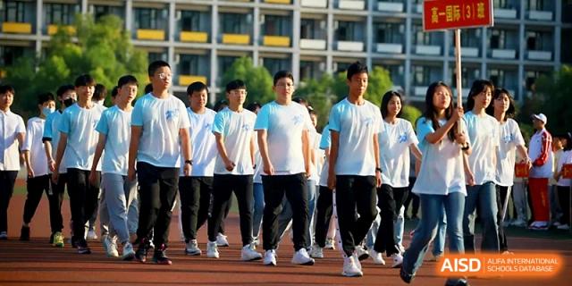 Students in blue and white sportswear stand in neat rows on the athletic field for a formal assembly at Zhengzhou No.1 High School