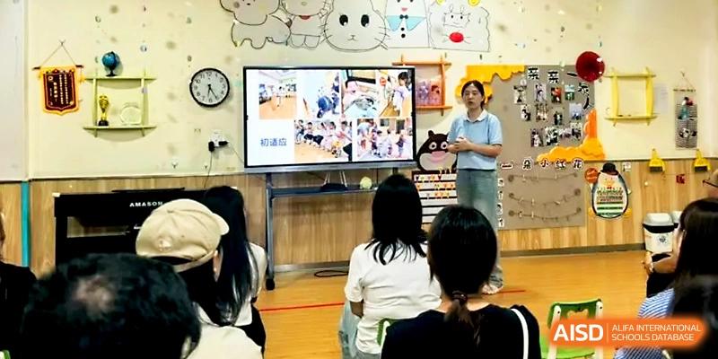 A female educator presents a slideshow to a group of parents and students in a modern classroom at Zhengzhou No.1&8 United International School