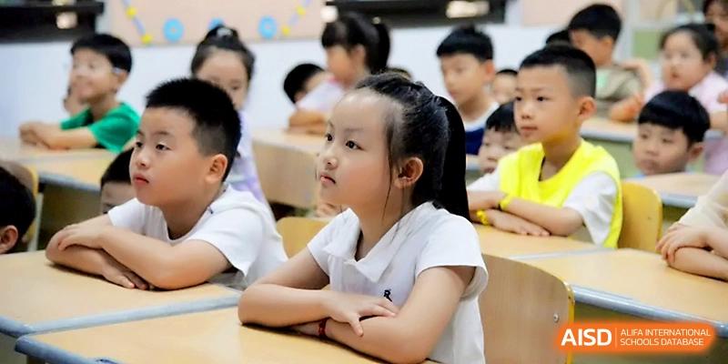 A young female student sits at her desk with a focused and curious expression during an engaging class at Zhengzhou No.1&8 United International School