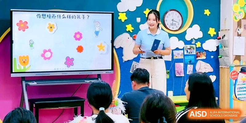A teacher in a blue shirt stands next to an interactive digital whiteboard during a creative lesson at Zhengzhou No.1&8 United International School