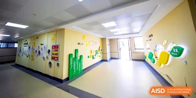 A bright and colorful hallway inside the school building with yellow walls and educational decorations at Zhengzhou No.1&8 United International School