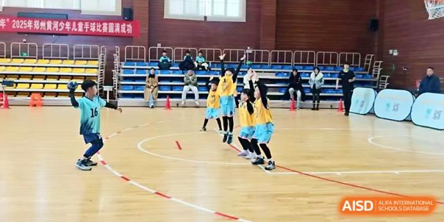 Students in sports gear participate in a synchronized basketball training exercise indoors at Zhengzhou No.1&8 United International School