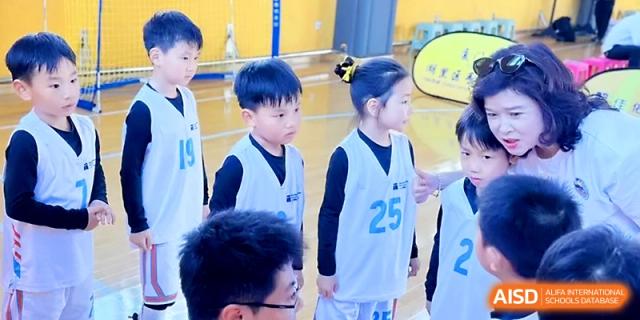 Young athletes in light blue jerseys listen to instructions before a competitive game at Zhengzhou No.1&8 United International School