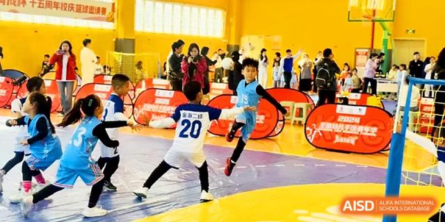 Two young boys compete for the ball during an energetic indoor soccer match at Zhengzhou No.1&8 United International School