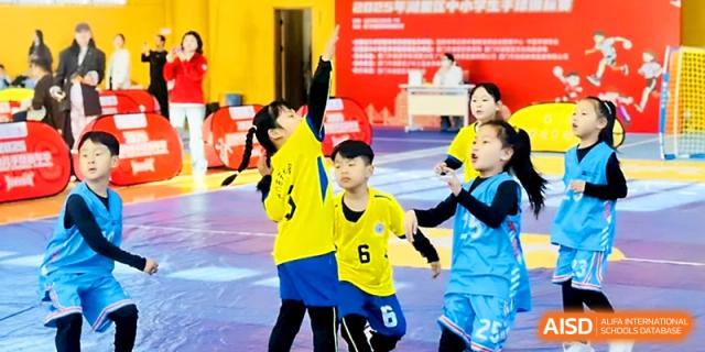 Young athletes in yellow and blue uniforms participate in a spirited indoor sports match at Zhengzhou No.1&8 United International School