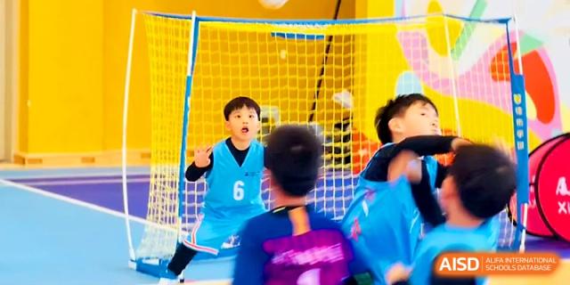 A young goalkeeper watches the action closely from the goal line during a soccer session at Zhengzhou No.1&8 United International School