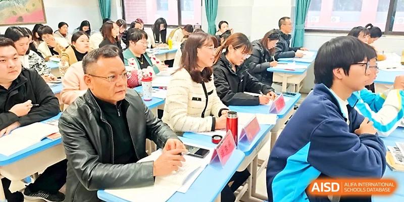 A group of parents and teachers sit at desks during an interactive school meeting or seminar session at Zhengzhou No.4 Middle School