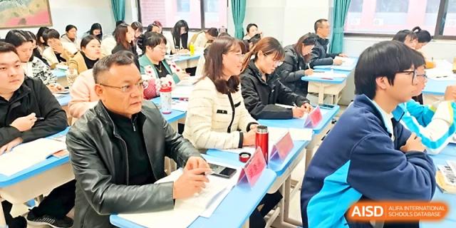 A group of parents and teachers sit at desks during an interactive school meeting or seminar session at Zhengzhou No.4 Middle School
