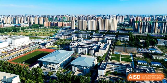 An aerial view of the expansive modern campus buildings and surrounding urban landscape at Zhengzhou No.4 Middle School