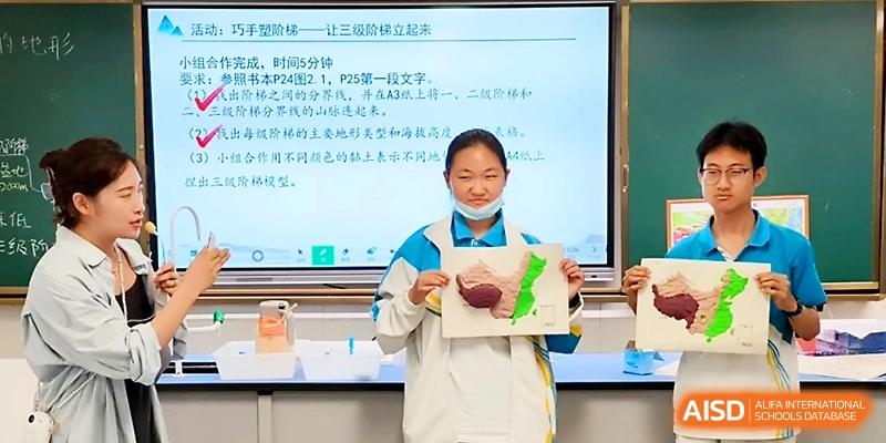 A student presenting a creative project in front of a digital screen at Zhengzhou No.4 Middle School.