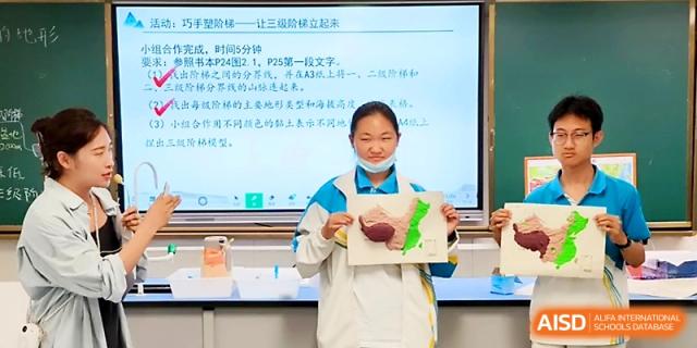 A student presenting a creative project in front of a digital screen at Zhengzhou No.4 Middle School.