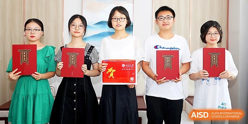 Three students proudly displaying their academic certificates and awards at Zhengzhou No.4 Middle School.