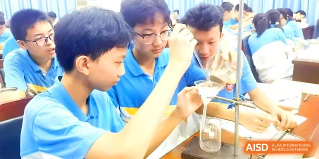 Students engaged in a hands-on chemistry experiment using a funnel at Zhengzhou No.4 Middle School.