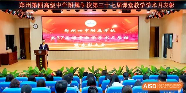 A large audience attending an educational conference in an auditorium at Zhengzhou No.4 Middle School.