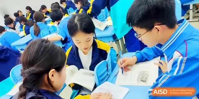 Students working in small groups, focused on their textbook lessons at Zhengzhou No.4 Middle School.