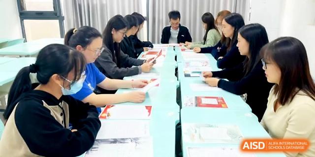 Teachers seated at a long table during an administrative briefing at Zhengzhou No.4 Middle School.