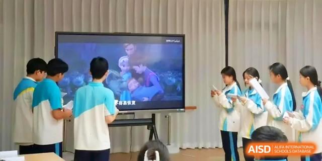 Students watching an educational video on a large mobile monitor at Zhengzhou No.4 Middle School.