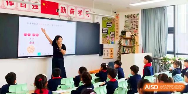 An enthusiastic teacher gesturing during an interactive primary lesson at Zhengzhou No.4 Middle School.