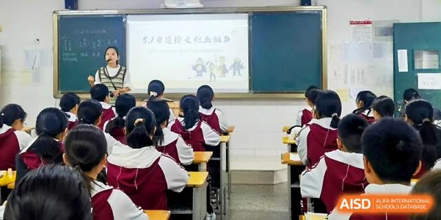 Students in uniform attending a lecture in a bright, clean classroom at Zhengzhou No.4 Middle School.