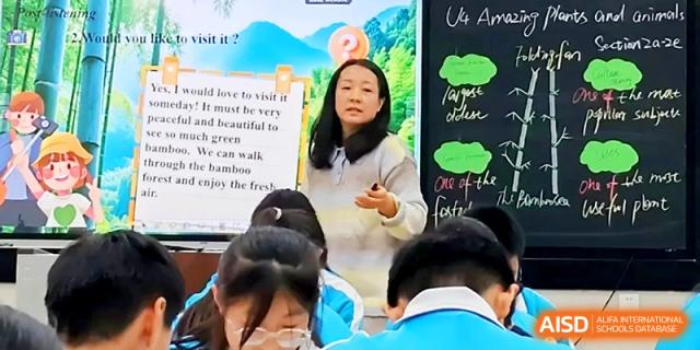 A teacher explaining English lessons using a colorful visual display at Zhengzhou No.4 Middle School.