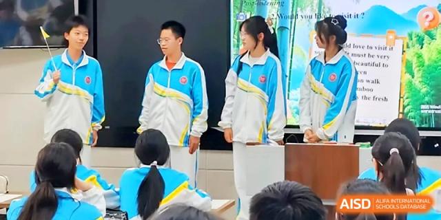 Students in tracksuits participating in a classroom presentation at Zhengzhou No.4 Middle School.