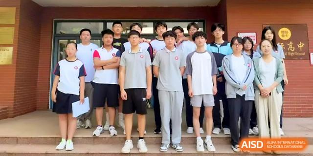 A row of male students in grey and white school uniforms stand together for a formal group portrait at Zibo International Academy At Hi-Tech Zone.