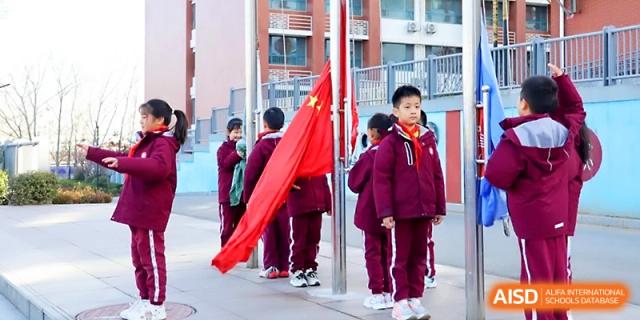 Students participate in a formal flag-raising ceremony on the school campus grounds at Zibo International Academy At Hi-Tech Zone.