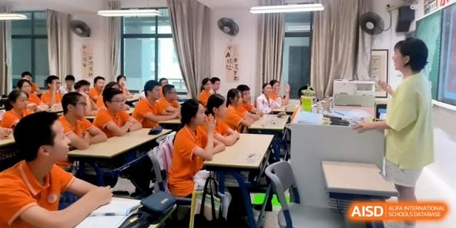 Students in orange shirts sit attentively at their desks during a classroom lesson at the Affiliated High School of Fujian Normal University.