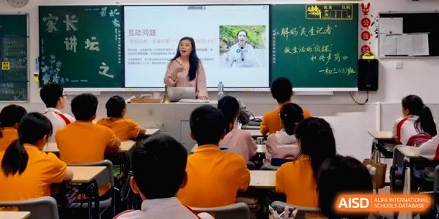 A teacher presents a slide with a portrait to a classroom of engaged students at the Affiliated High School of Fujian Normal University.