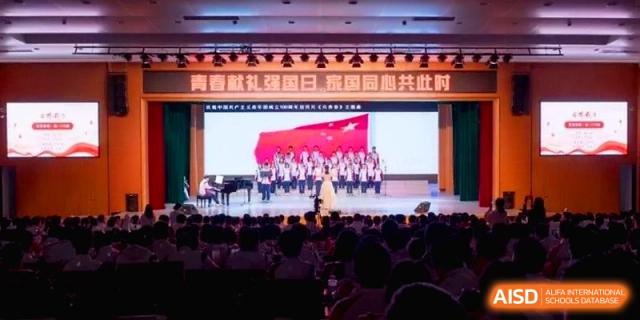 A large choir performs on a stage with a digital backdrop of the national flag at the Affiliated High School of Fujian Normal University.