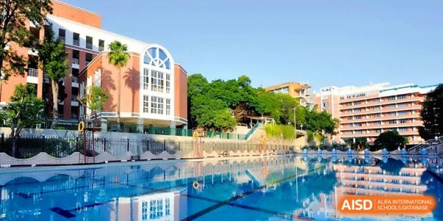An outdoor swimming pool reflects the modern campus buildings and green trees at the Affiliated High School of Fujian Normal University.