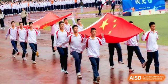 Students march across the athletic field carrying a large national flag at the Affiliated High School of Fujian Normal University.