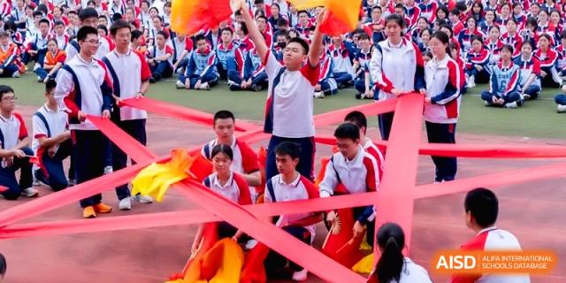 A group of students performs a spirited choreographed dance with red ribbons at the Affiliated High School of Fujian Normal University.