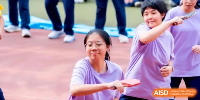 A female student smiles while playing a game of table tennis on the school court at the Affiliated High School of Fujian Normal University.
