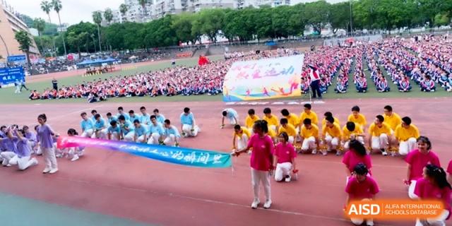 A large group of students march behind a colorful banner at the Affiliated High School of Fujian Normal University.