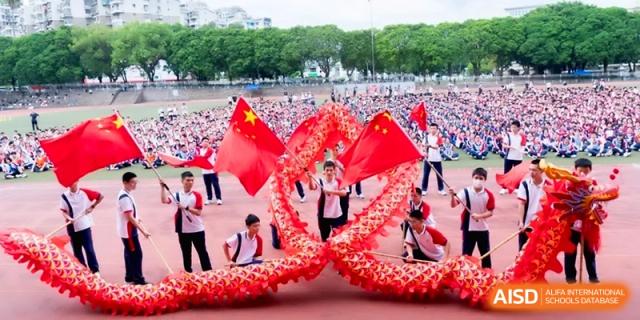 Students perform a dragon dance with red flags on a track at the Affiliated High School of Fujian Normal University.
