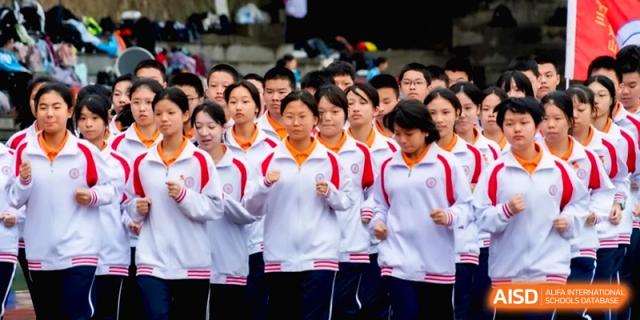 Close-up of students in white and red uniforms marching on a track at the Affiliated High School of Fujian Normal University.