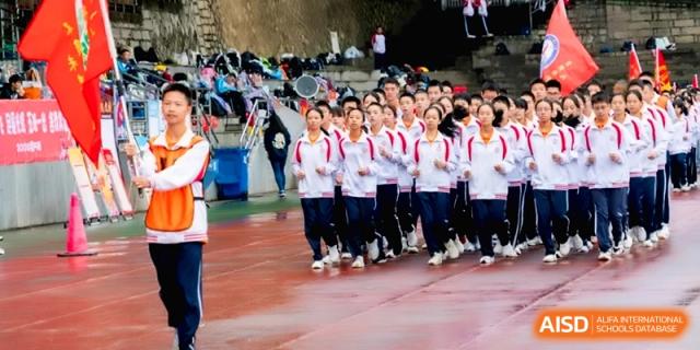 Rows of students in white tracksuits march in unison during a ceremony at the Affiliated High School of Fujian Normal University.